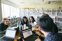 Group of high school students studying together in the library