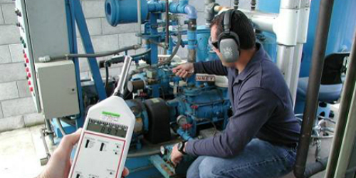 Mechanic testing generator while technician measures sound levels.