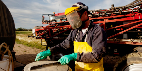 Worker opening pesticide spray tank