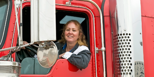 Photo of Truckdriver Sitting in the Cab of a Truck