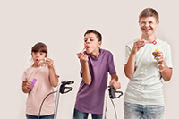 Three disabled kids blowing bubbles