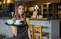 Young waitress holding serving tray