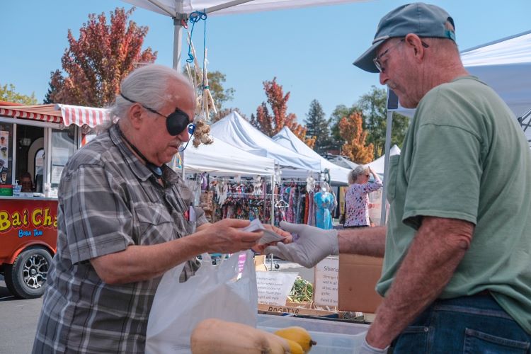 Man buying food at farmers market with an EBT card