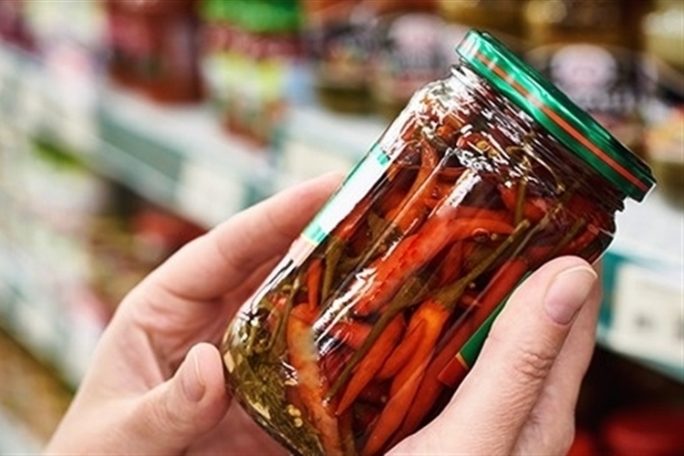 Person holding jar of peppers at a local Food Bank